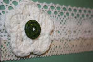 Green board with crocheted woolen flower with button centre | rearticulated.wordpress.com